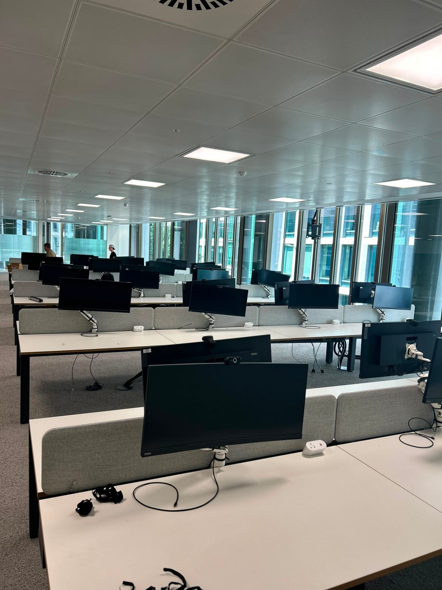 Office fit-out installation London — rows of bench desks with monitor arms professionally installed by Movir London